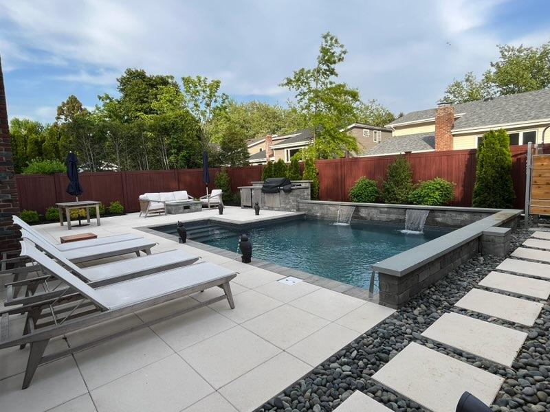 pool patio with large slab pavers and sheer descent waterfall